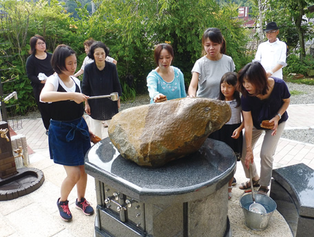 墓石に水を注ぎ清め、「よし よし」となぜる